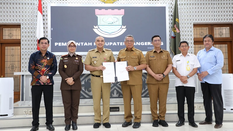 Bupati Tangerang Ahmed Zaki Iskandar dan Walikota Tangsel Benyamin Davnie menunjukan surat penandatanganan serah terima hibah dua bidang TPU/Repro