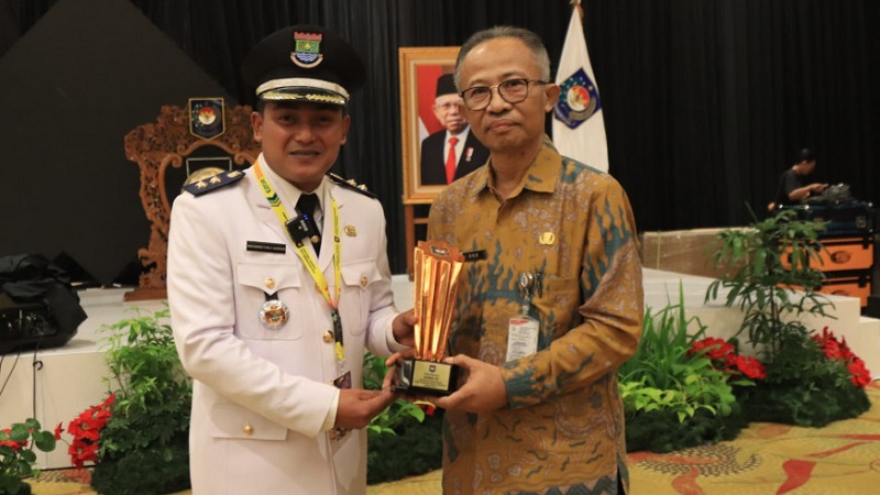 Lurah Cisauk Moch. Farly Gusriadi menerima penghargaan kelurahan terbaik ketiga tingkat nasional. (Foto: Dok Pemkab)