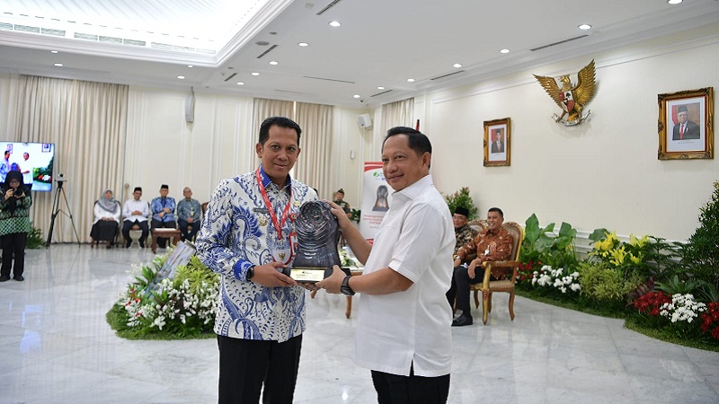 Menteri Dalam Negeri Tito Karnavian menyerahkan penghargaanParitrana Award kepada Pj Bupati Tangerang Andi Ony d. (Foto: Dok Pemkab)