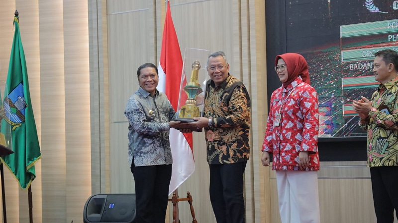 Walikota Tangsel Benyamin Davnie menerima Piala dari Pj Gubernur Banten Al Muktabar. Pemkot Tangsel menjadi daerah terbaik Badan Publik paling informatif. (Foto: Dok Pemkot)