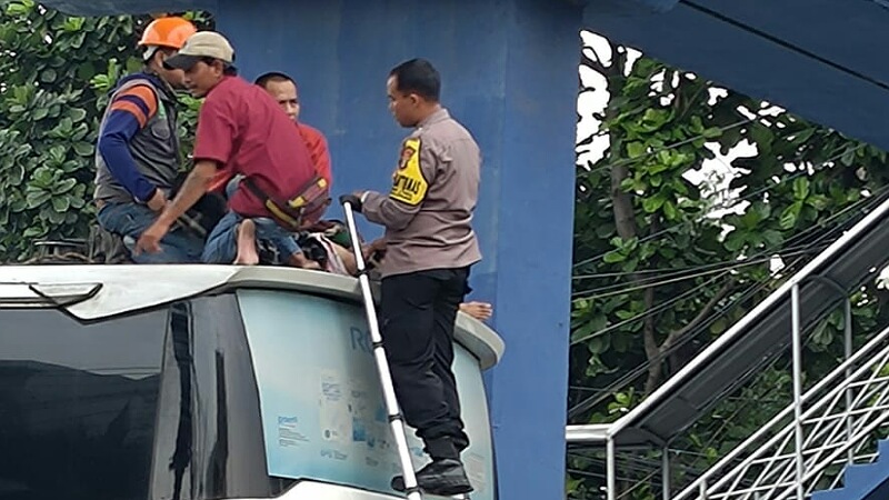 Proses evakuasi pria yang diduga ingin bunuh diri di atap bus Sinar Jaya. Foto: Repro
